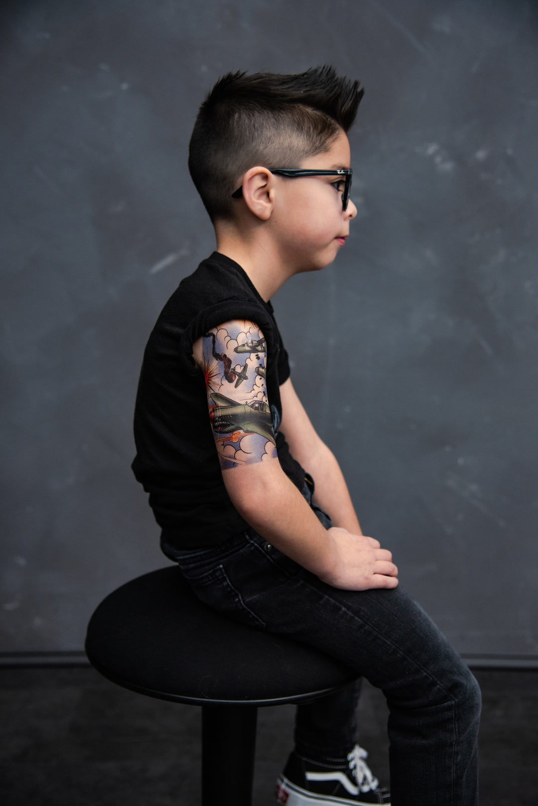 Side view of child showing off his fake army tattoo.