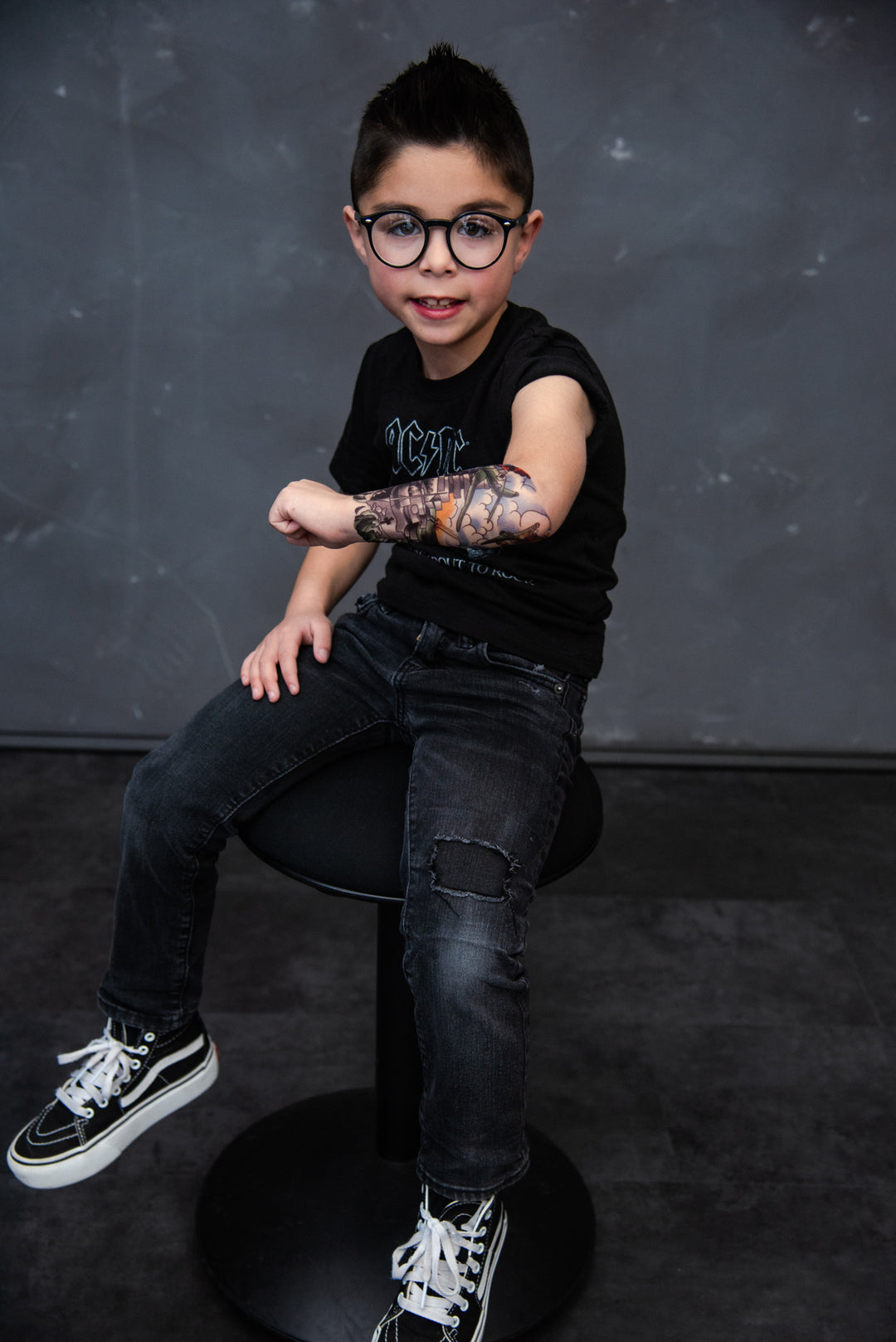 Little boy showing off his military themed temporary tattoo on his forearm.
