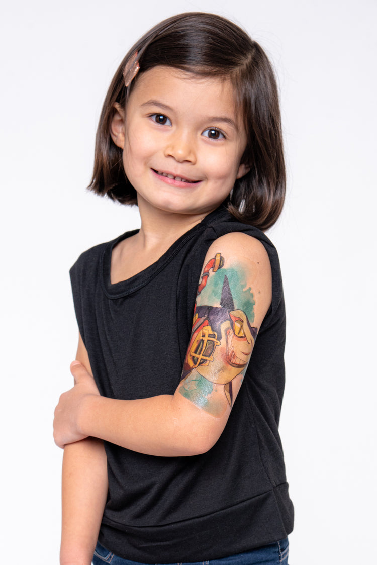 Young girl shows off Sharks temporary tattoo sleeve on her upper arm. Blue and red colors are the most abundant.