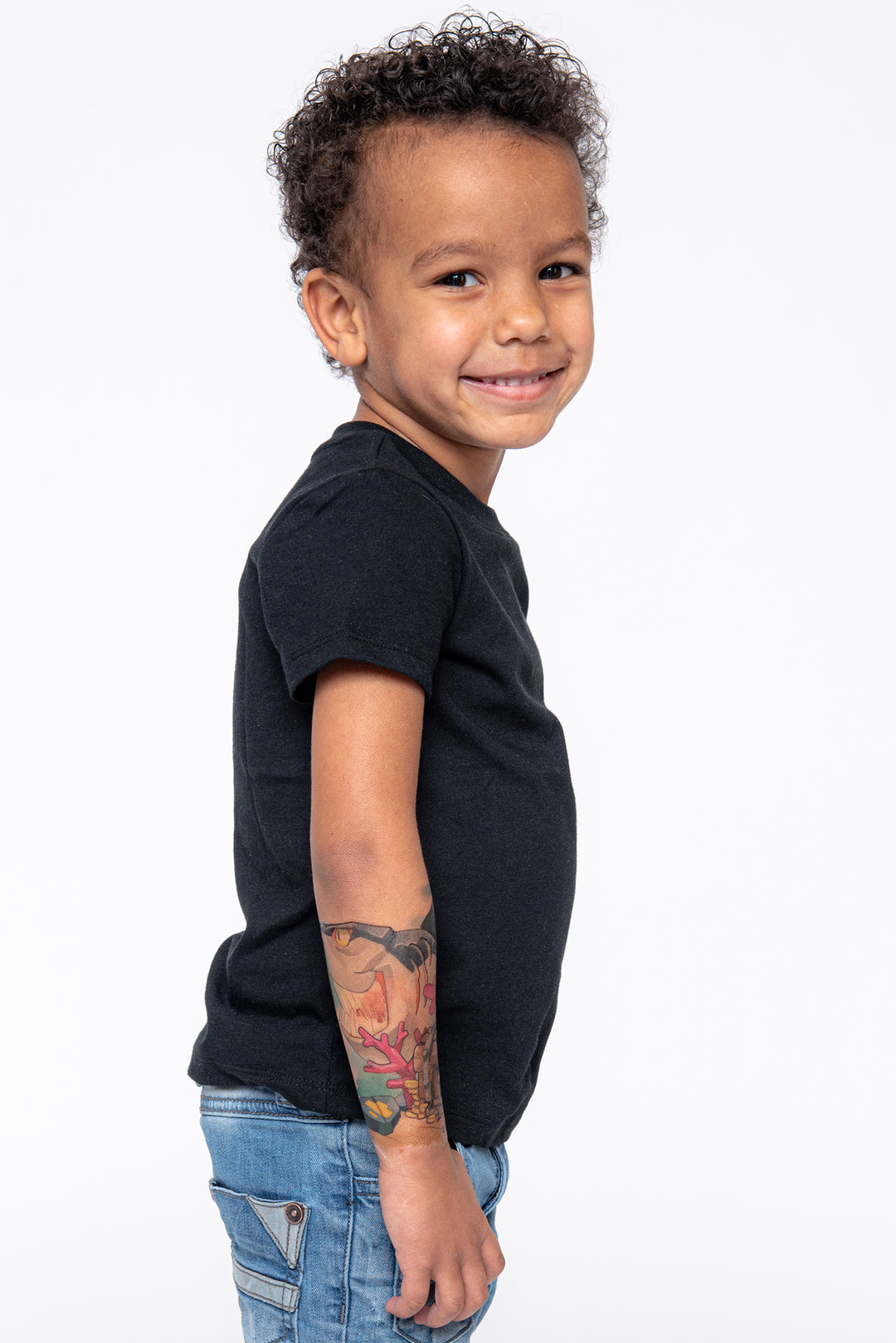 Young boy shows his shark tattoo on the forearm.