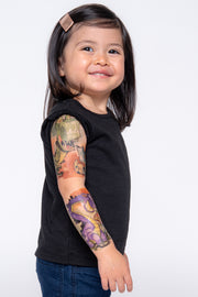 Little girl smiles and shows off her dinosaur temporary tattoo sleeve.