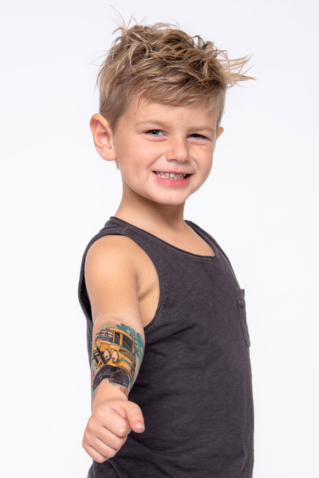 Young boy shows off his forearm temporary tattoo sleeve with construction equipment.
