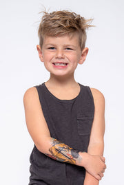 Front view of young boy wearing construction temporary tattoo sleeve on lower arm.