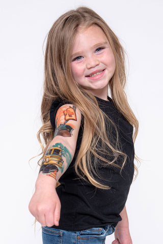 Young girl excitedly shows her full construction temporary tattoo sleeve.