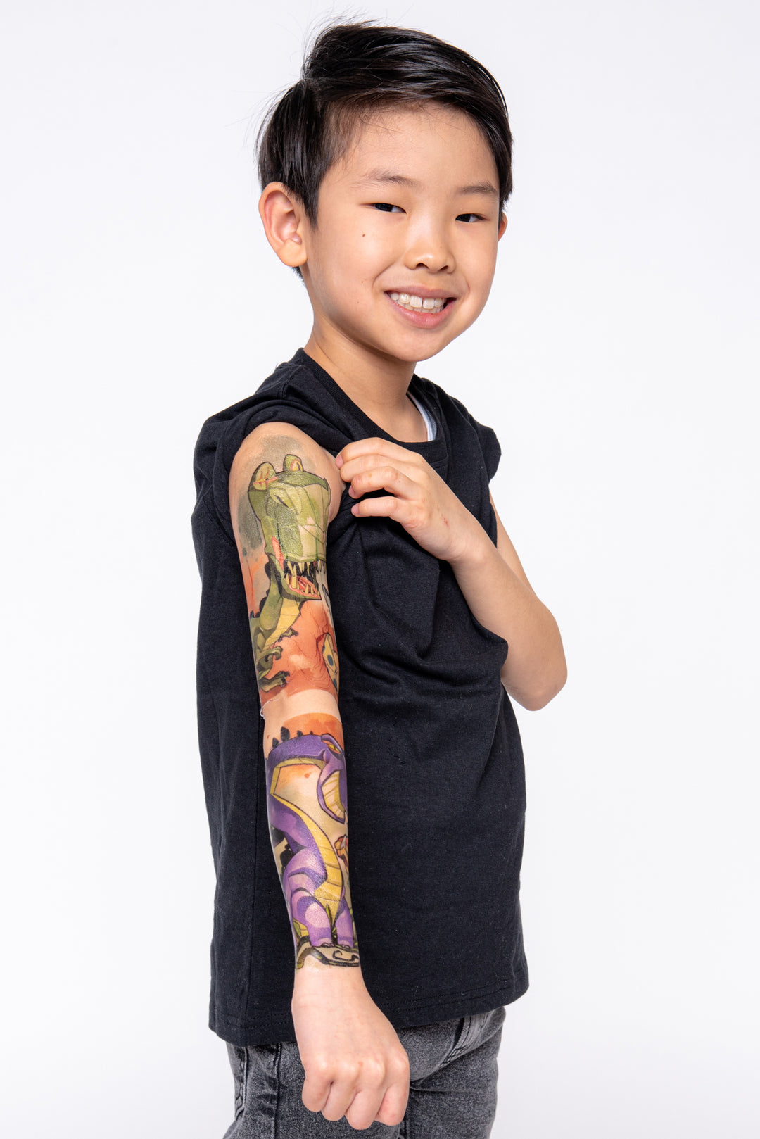Boy shows off his dinosaur full sleeve temporary tattoo.