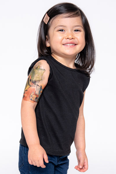 Little girl has a big smile to show off her temporary tattoo with a t-rex